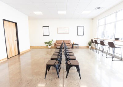 Spacious chiropractic office waiting room with chairs and natural light.