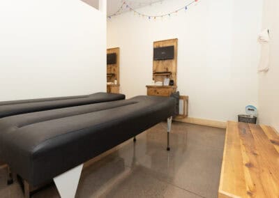 Chiropractic treatment room with massage table and wooden wall decor.