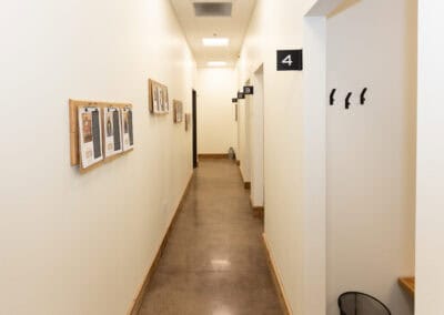 Clean, well-lit hallway in Ignite Chiropractic clinic with numbered rooms.