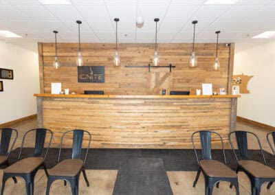 Modern chiropractic office reception with wooden decor and seating area.