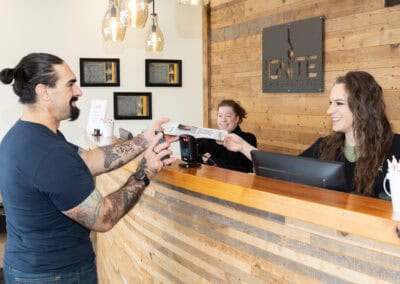 Patient at reception desk interacting with staff at Ignite Chiropractic.