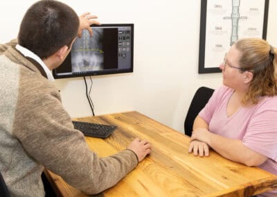 Chiropractor reviewing spinal X-ray with patient at Ignite Fargo.