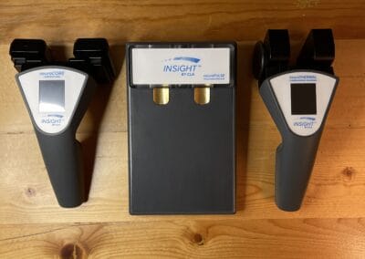 Chiropractic spinal analysis devices on wooden table for health assessment.